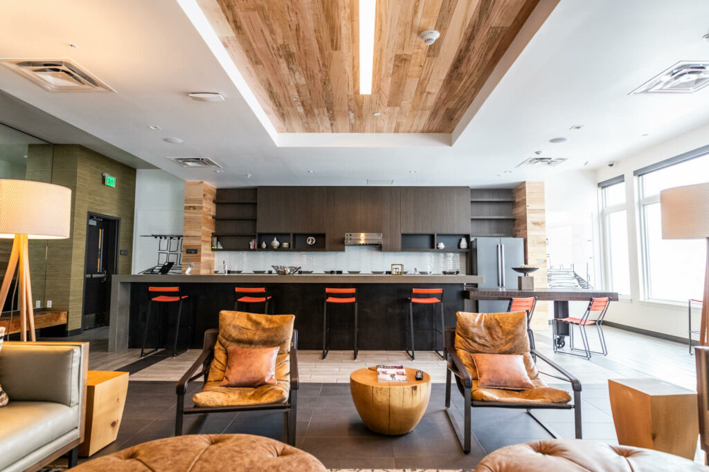 Dark and light tile floor with two leather chairs and kitchen behind.